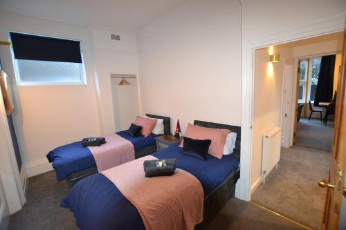 Zimmer mit 2 Betten und Flur in der Unterkunft Mayflower 2 bed Boutique Apartment - STAYSEEKERS in Salisbury