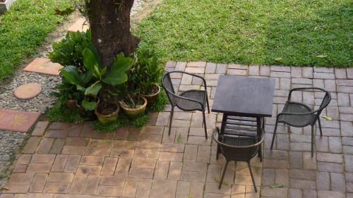 a table and chairs sitting next to a tree at Pak Ping Rim Khong in Chiang Saen