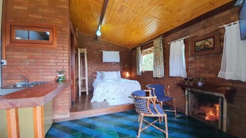 a bedroom with a bed and a fireplace in a room at Chales Edelweiss in Visconde De Maua