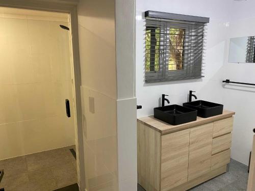 a bathroom with two sinks and a shower at Adelaide Brownhill Creek Tourist Park in Adelaide