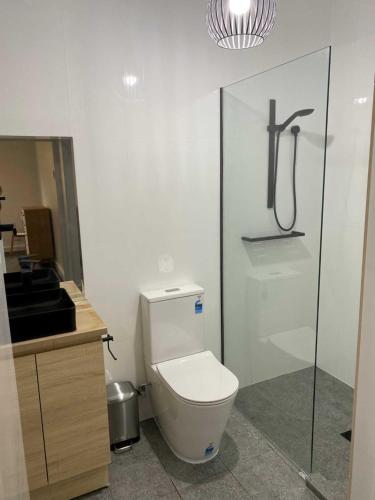 a bathroom with a toilet and a glass shower stall at Adelaide Brownhill Creek Tourist Park in Adelaide