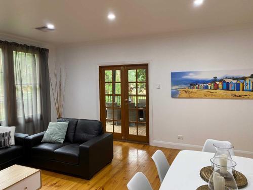 a living room with a black couch and a table at Adelaide Brownhill Creek Tourist Park in Adelaide