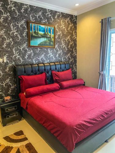 a red bed with red pillows in a bedroom at AL Marina Resort in Puncak