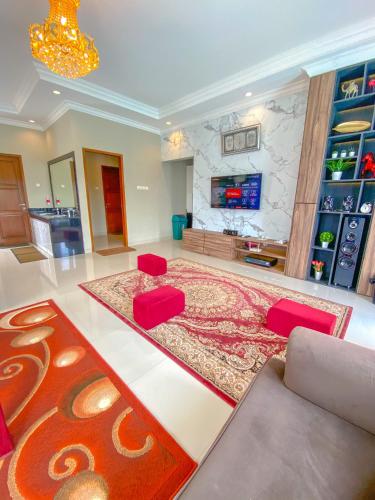 a large living room with a couch and red chairs at AL Marina Resort in Puncak