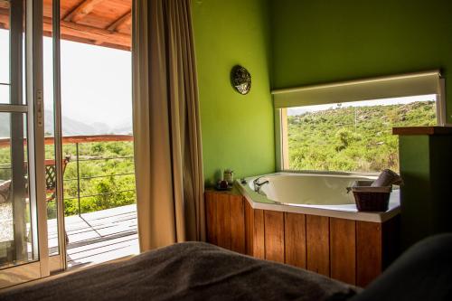 uma casa de banho verde com uma banheira e uma janela em Monte Adentro em Capilla del Monte