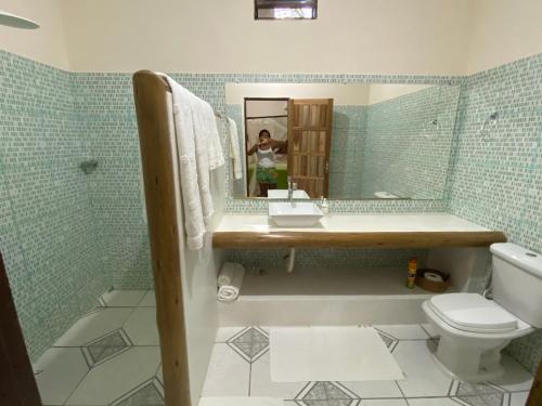 a bathroom with a sink and a toilet and a mirror at Casa Nice Trancoso in Trancoso