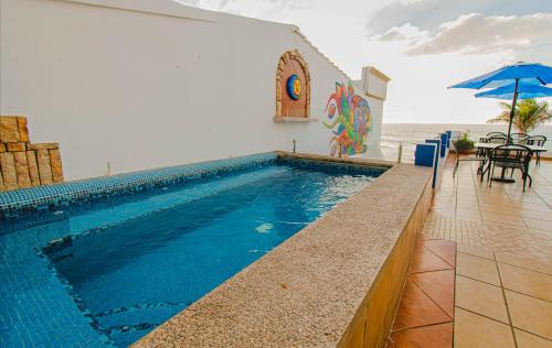 - une piscine avec une table et un parasol dans l'établissement Departamentos Claussen, à Mazatlán