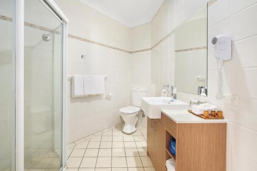 uma casa de banho com um WC, um lavatório e um chuveiro em Terrigal Sails Serviced Apartments em Terrigal