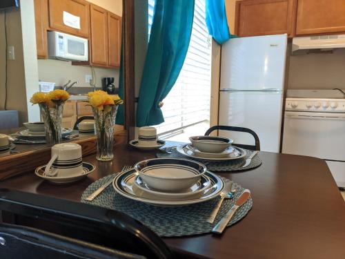 a kitchen with a table with plates and dishes on it at Athens Hotel & Suites in Houston