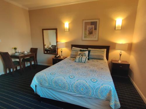 a bedroom with a bed and a table and a mirror at Athens Hotel & Suites in Houston