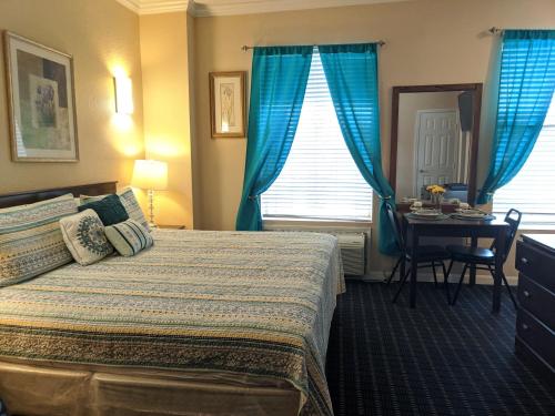 a hotel room with a bed and a table with a desk at Athens Hotel & Suites in Houston