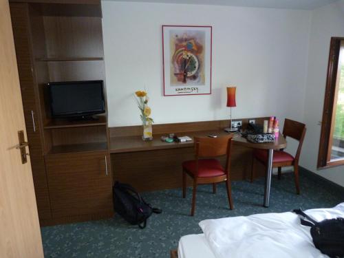 a hotel room with a bed and a desk and a television at Hotel Krone in Haigerloch