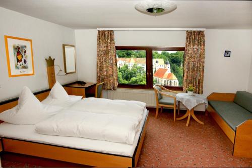 ein Schlafzimmer mit einem Bett, einem Sofa und einem Tisch in der Unterkunft Hotel Krone in Haigerloch