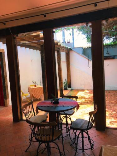a patio with a table and chairs and a table at Del Mundo Hostel in São João del Rei