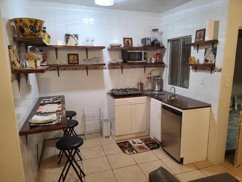 a kitchen with a sink and a table with stools at Casa Amorosa in Tecate