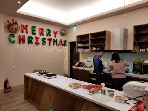 two people standing in a kitchen preparing food at 無盡夏民宿 in Nanzhuang