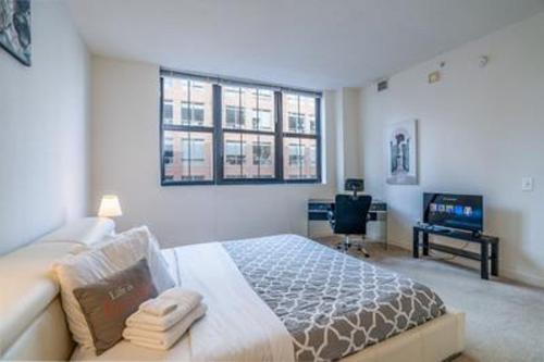 Un dormitorio con una cama grande y un televisor. en Heaven On Baltimore at Harborfront, en Baltimore