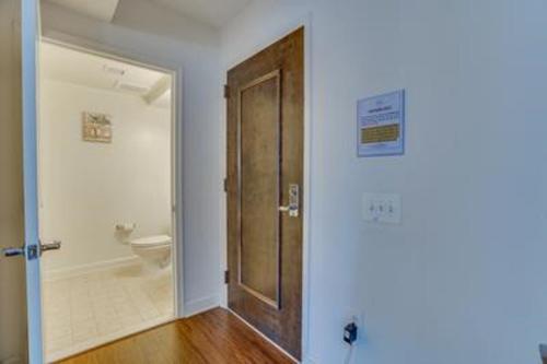 Un baño con inodoro y puerta de madera. en Heaven On Baltimore at Harborfront, en Baltimore