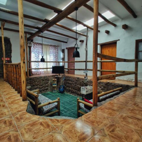 an empty room with a stage and wooden beams at Rey Lagarto Hostel in San Pedro de Atacama