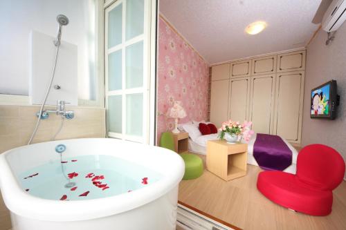 un bagno con vasca e una camera da letto di Avica Homestay a Wujie