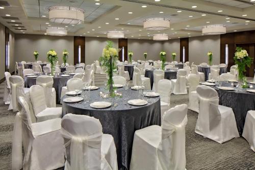 a banquet hall with tables and white chairs at Crowne Plaza - Chicago West Loop by IHG in Chicago