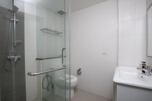 a bathroom with a shower and a toilet and a sink at The Patong Center Hotel in Patong Beach