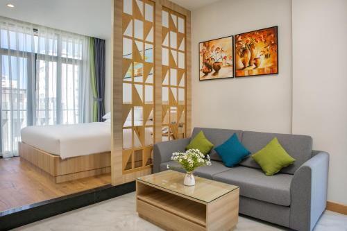 a living room with a couch and a bedroom at Sun River Hotel & Apartment in Da Nang