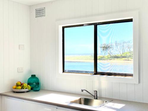 a kitchen counter with a sink and a window at The Beach Arrawarra in Arrawarra