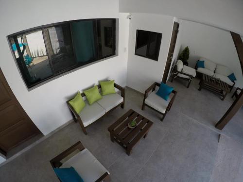 Suchitoto的住宿－Hotel Jardin De Las Marias，享有客厅的顶部景致,客厅配有沙发和椅子