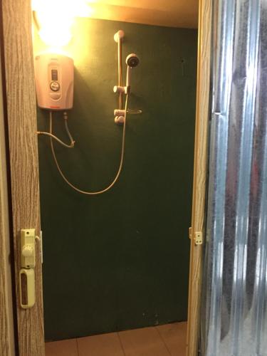 a green door with a hair dryer on a wall at Hikers Sleep Port Guesthouse in Cameron Highlands