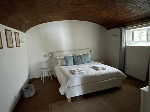 a bedroom with a white bed and a window at Casa Teresa in Évora