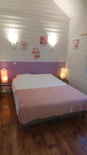 um quarto com uma cama grande com duas luzes em Le Village Enchanteur em La Chapelle-Aubareil