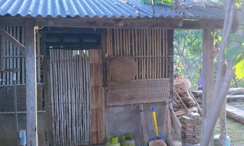 a small building with a blue roof and a fence at ESA di Kubu Homestay in Singaraja