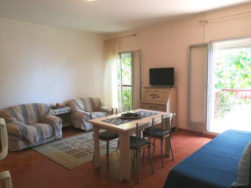 a living room with a table and chairs and a tv at Casa Romeo in Taormina