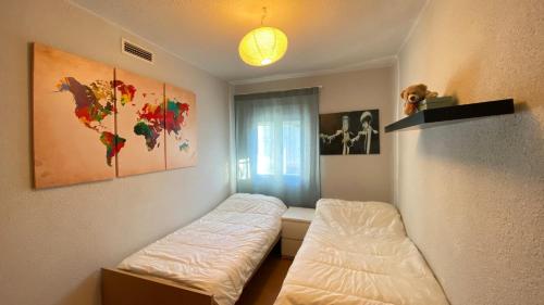 1 dormitorio con 2 camas y un mapa del mundo en Apartamento Aluche con parking gratuito, en Madrid