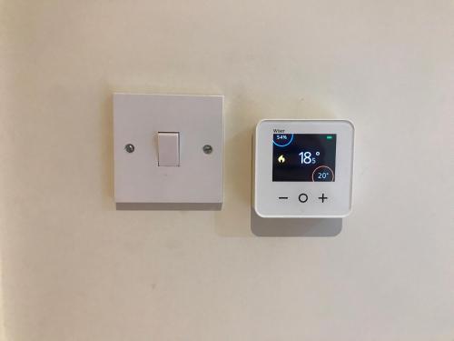 an electrical outlet on a wall with an ipod on it at Studio-2 Staines,Heathrow, London-own entrance in Staines