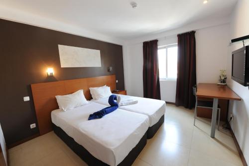 Postel nebo postele na pokoji v ubytování Inn Luanda