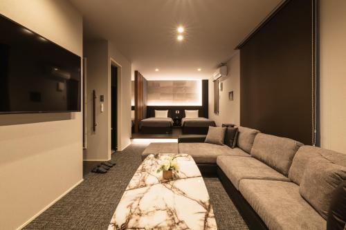 a living room with a couch and a tv at GRAND BASE Hakata Premium in Fukuoka