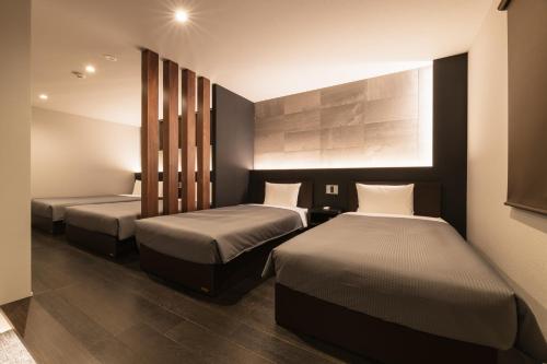 Postel nebo postele na pokoji v ubytování GRAND BASE Hakata Premium