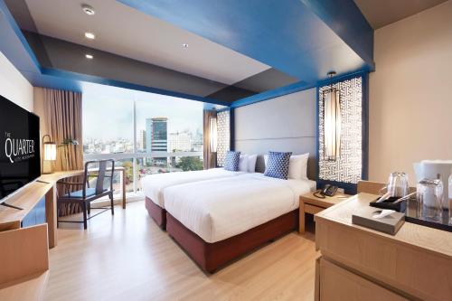 a hotel room with a bed and a large window at The Quarter Hualamphong by UHG in Bangkok