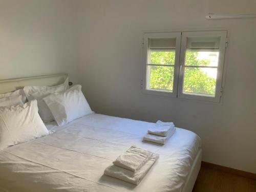a bedroom with a white bed with two towels on it at Casa Carmo in Évora