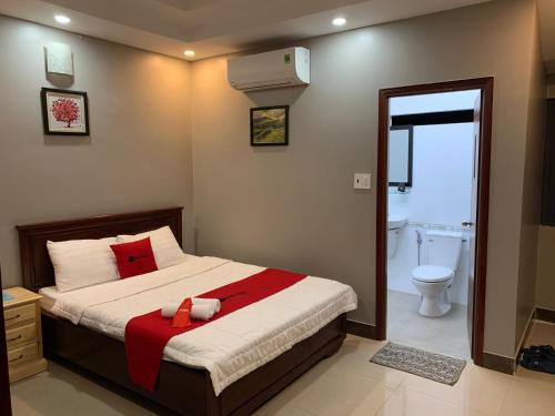 ein Schlafzimmer mit einem Bett und ein Badezimmer mit einer Toilette in der Unterkunft Bờ Sông Hotel in Ho-Chi-Minh-Stadt