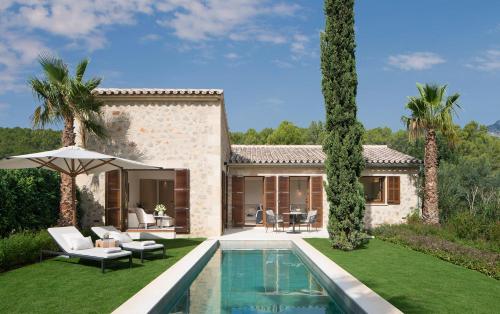 a villa with a swimming pool and a house at Castell Son Claret - The Leading Hotels of the World in Capdellá