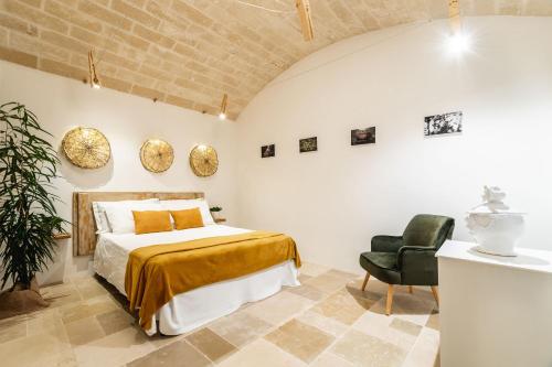 a bedroom with a bed and a chair at Sorelle Barnaba Country House in Monopoli