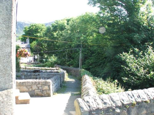a stone retaining wall next to a building at Pen Llyn Quarryman's Cottage in Trefor
