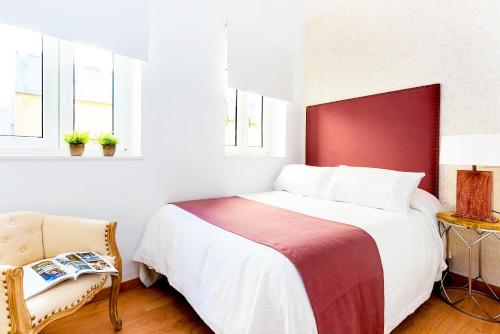 1 dormitorio con 1 cama con cabecero rojo y silla en Genteel Home Lope de Rueda, en Sevilla