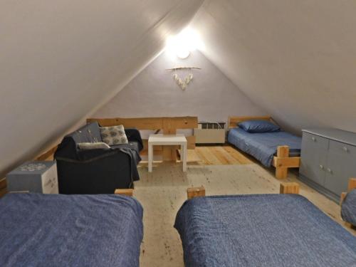 a attic room with two beds and a table at Domki - Mazurski Zaścianek in Kruklanki