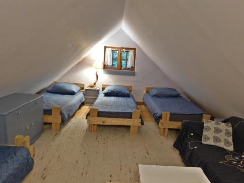 a attic room with three beds and a couch at Domki - Mazurski Zaścianek in Kruklanki