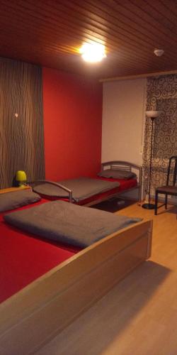 two beds in a room with red walls at Monteurunterkunft Haus Barbara Pirmasens in Pirmasens