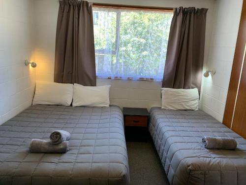 2 Betten in einem Zimmer mit Fenster in der Unterkunft Cumberland Motel in Dunedin